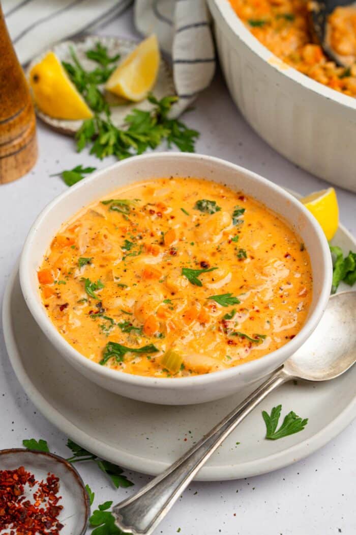 Tuscan white bean kale soup served in a large bowl with fresh herbs.