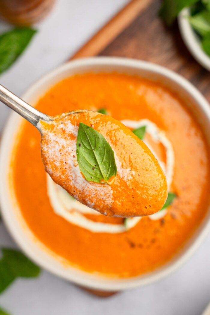 A spoonful of vegan high protein soup in the foreground of the picture, with the rest of the bowl visible behind.