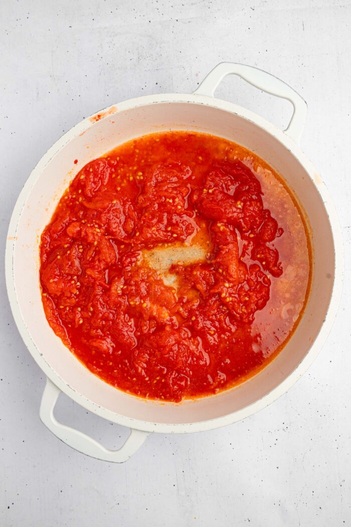 Cooked tomatoes rughly mashed with a fork for a rustic sauce.
