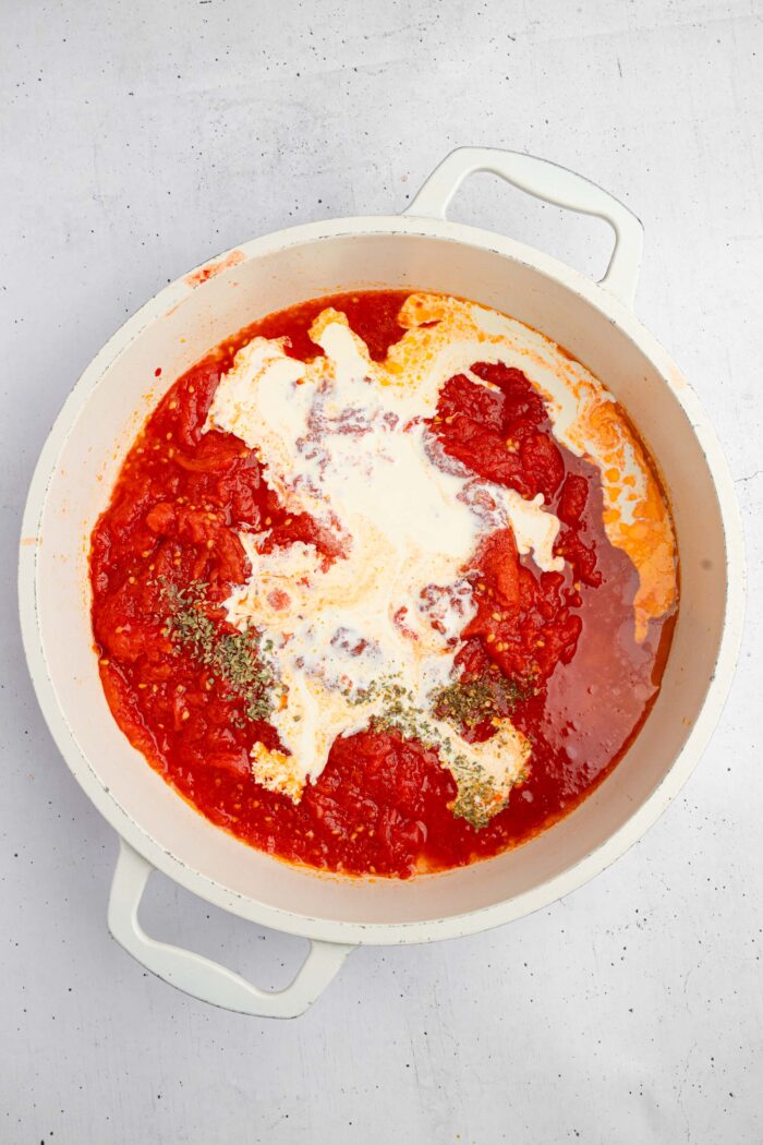 Coconut milk, broth, and herbs are added into the pan to make a creamy sauce.