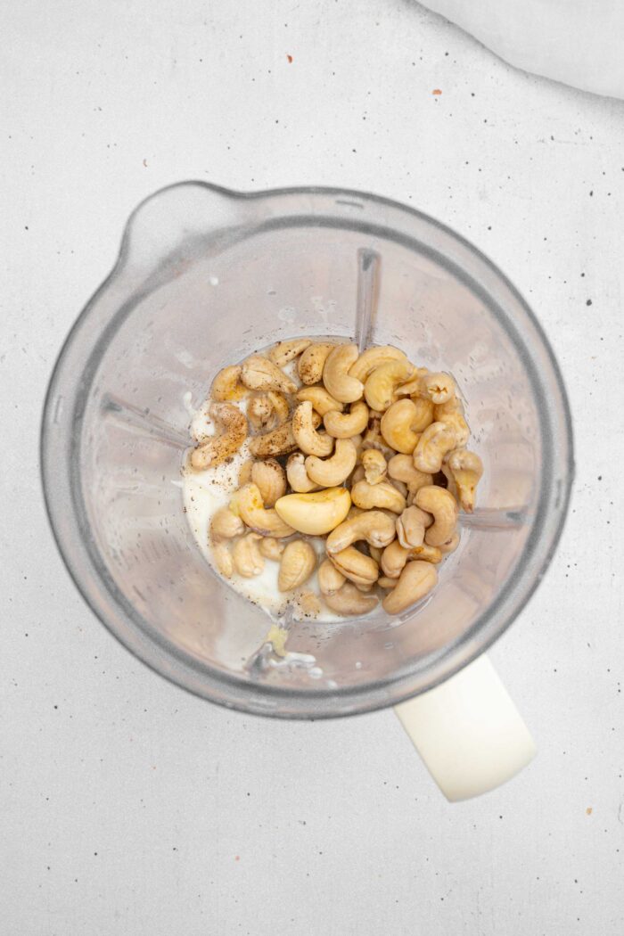 The ingredients for the dip base (vegan Skyr yogurt and cashews plus seasonings) in a high-speed blender.