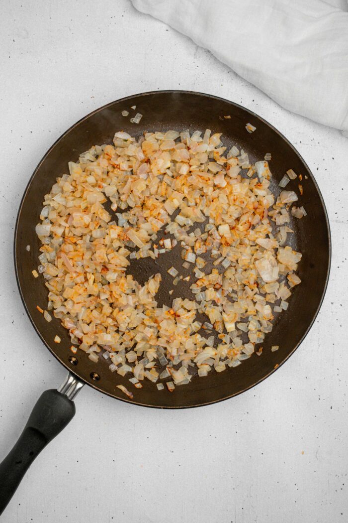 Onions fried up in a large skillet.