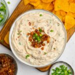 Caramelized Onion Dip served with more onions, fresh chives, and chips for dipping.