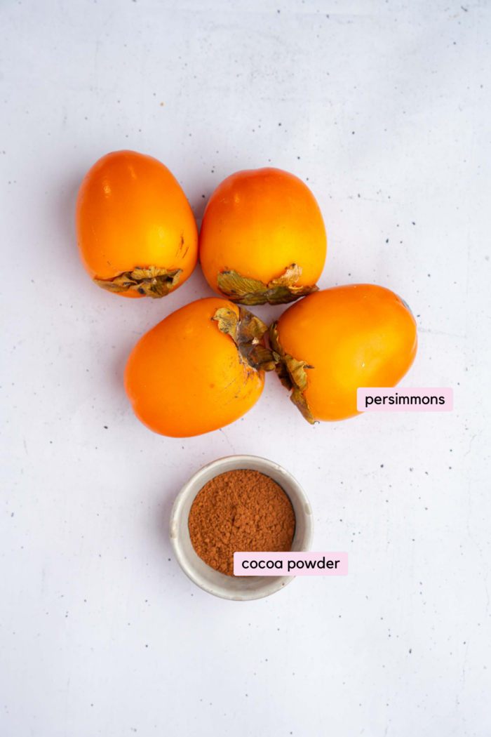 Ingredients for the persimmon pudding laid out and labeled on a light neutral background.