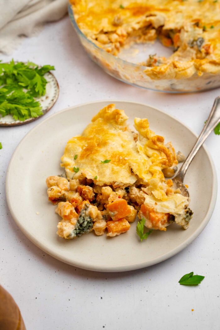 Tuscan chickpea pot pie served on a ceramic plate woth a fork picking up a piece.