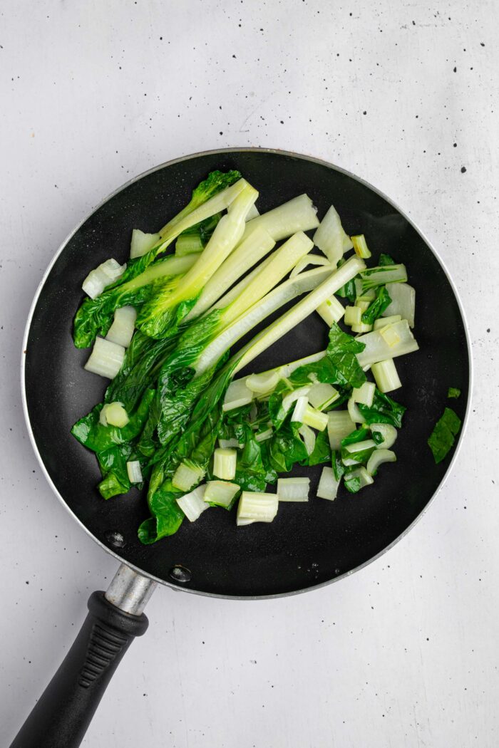 Sauteed bok choy in a frying pan.