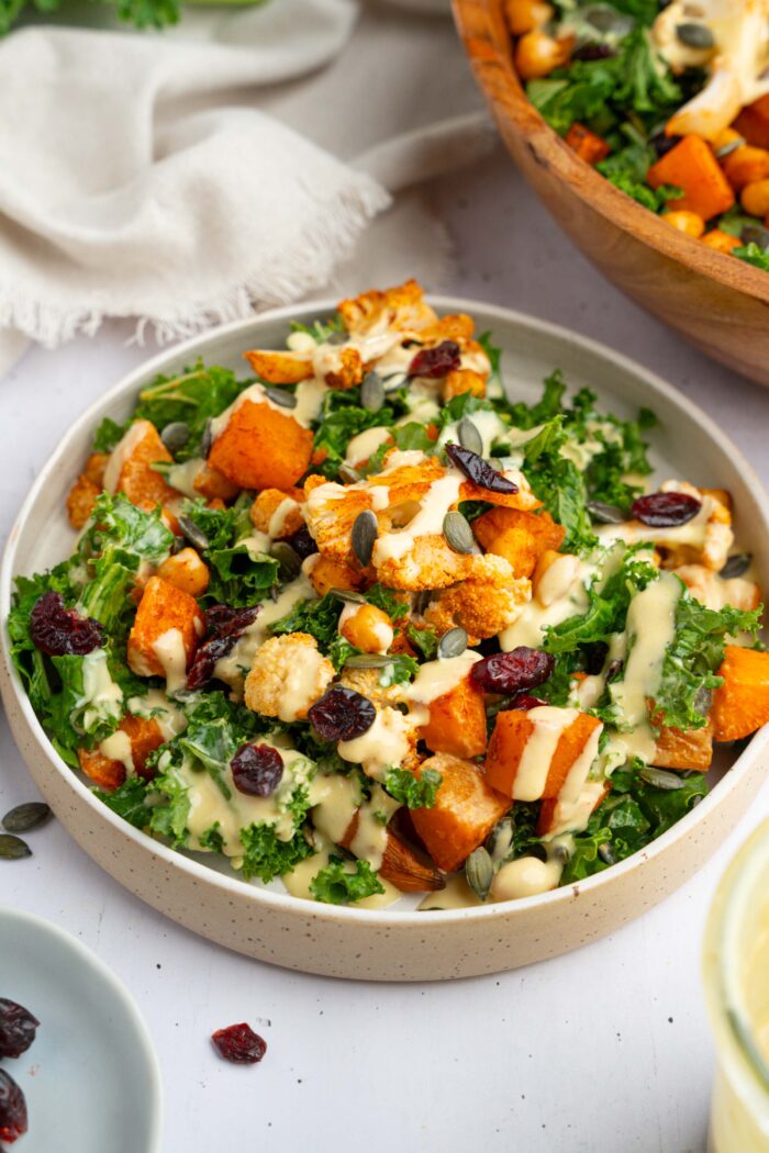 Winter kale salad, mixed in a bowl with the dressing poured over the top.
