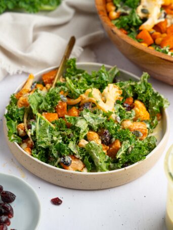 A serving of fully mixed winter kale salad with maple-mustard tahini dressing.