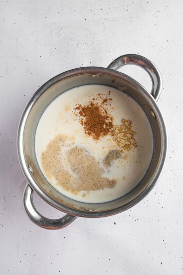 A steel saucepan with warm date milk ingredients before being mixed together.