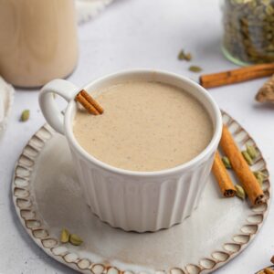 Warm date milk served with a cinnamon stick in a beautoful ceramic mug.