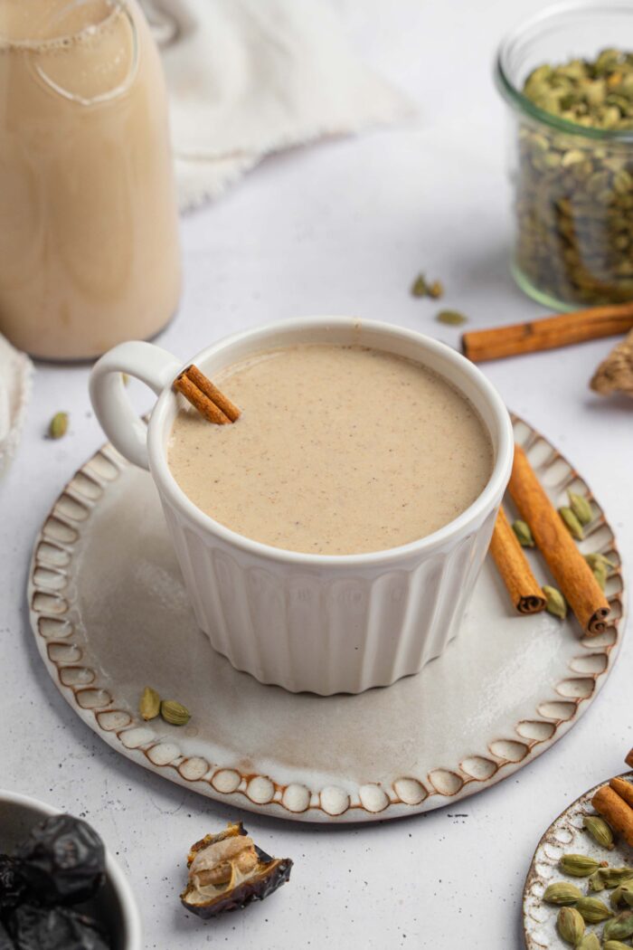 Warm date milk served with a cinnamon stick in a beautoful ceramic mug.