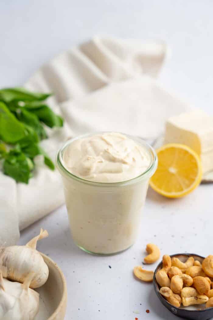 Tofu cream transferred into a clear jar, with the ingredients visible in the background.