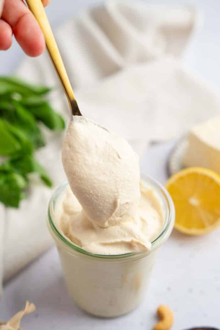 A spoonful of tofu cream being lifted out of the jar.