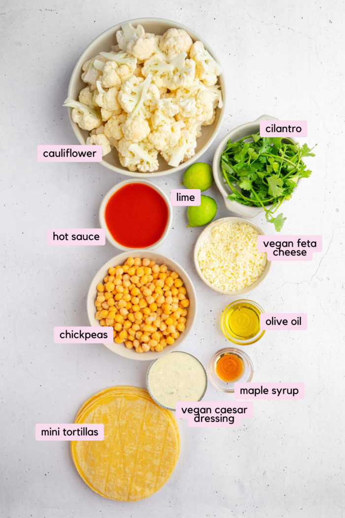 The ingredients for buffalo chickpea cauliflower tacos laid out and labeled on a flat white background.