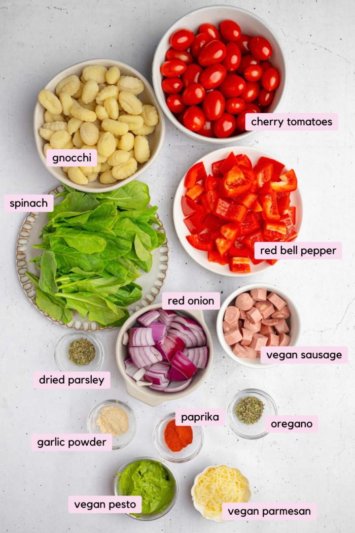 The ingredients for sheet pan gnocchi laid out and labeled on a clear white background.