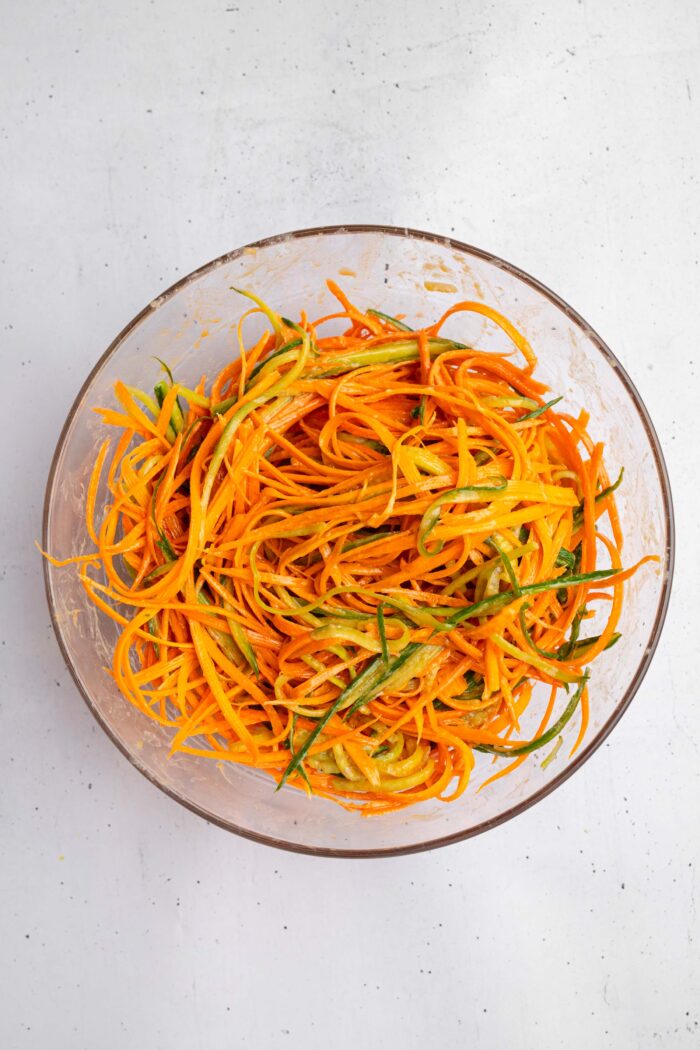 Carrots and cucumber mixed together in a salad bowl.