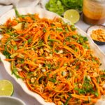 Carrot and cucumber salad served in a large oval serving dish.