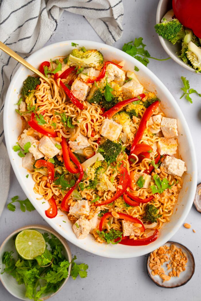 A dish of ramen noodle bake, freshly mixed together, with a fork sticking out.