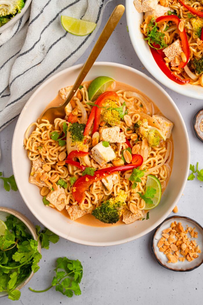 Title image depicts a bowl of ramen noodle bake served with crushed peanuts and cilantro.