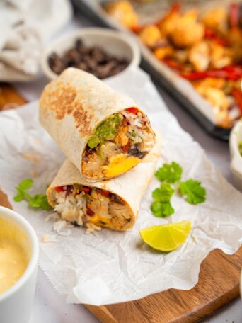 One of cauliflower burritos served after air frying, cut in half and showing off the cross section.