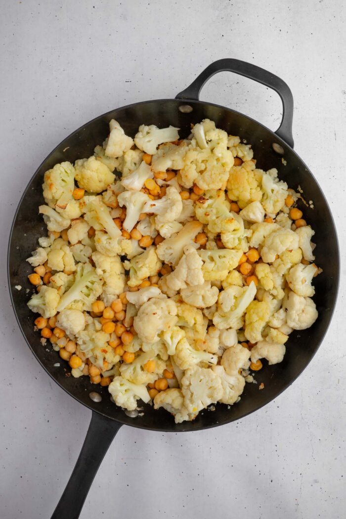 Clooked cauliflower and chickpeas in a large iron skillet.