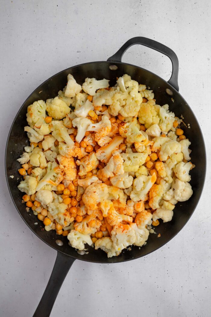 Creamy hot sauce added to the skillet with cauliflower and chickpeas to make the filling for the tacos.