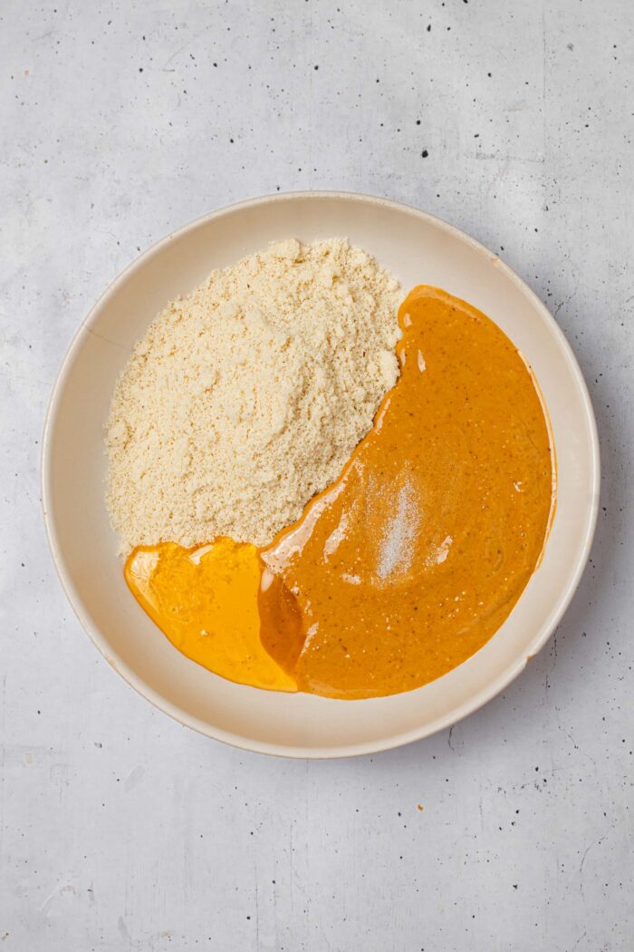 Peanut butter, almond flour, maple syrup, and salt in a bowl.