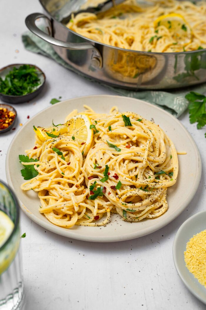A serving of easy vegan alfredo pasta on a white ceramic plate.