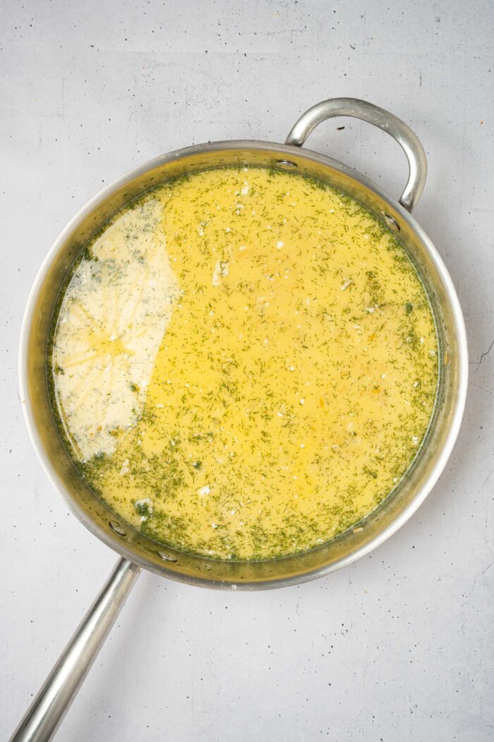 Orzo and liquid ingredients in a large pan.