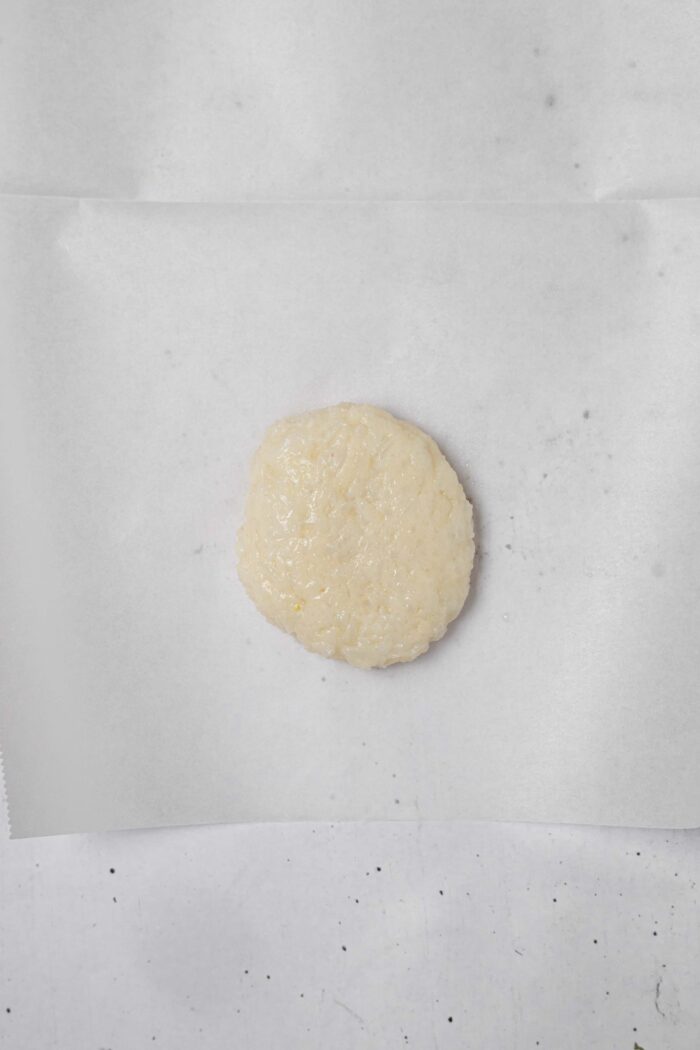 A ball of rice tortilla dough on a parchment sheet.
