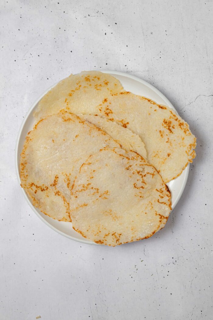 Rice tortillas on a plate, overlapping each other.