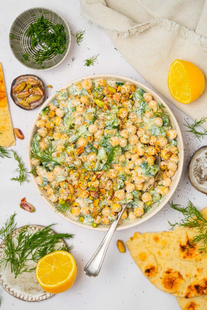 A top down photo of tzatziki chickpea salad in a large shallow salad bowl.
