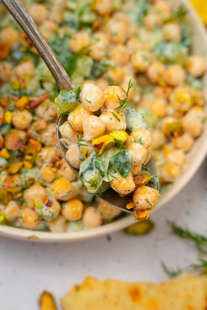 A close up of tzatziki chickpea salad being scooped up with a spoon.
