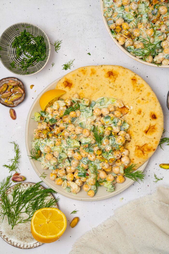 A serving of tzatziki chickpea salad on a pita.