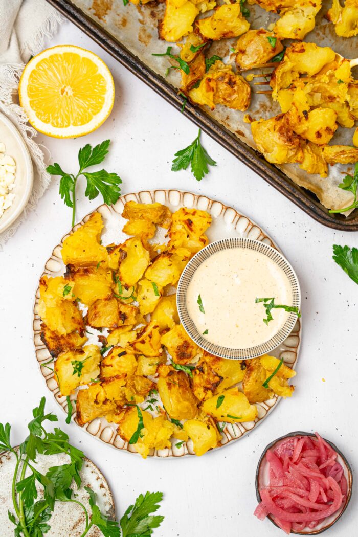 Top down view of shaken potatoes served with dipping sauce.
