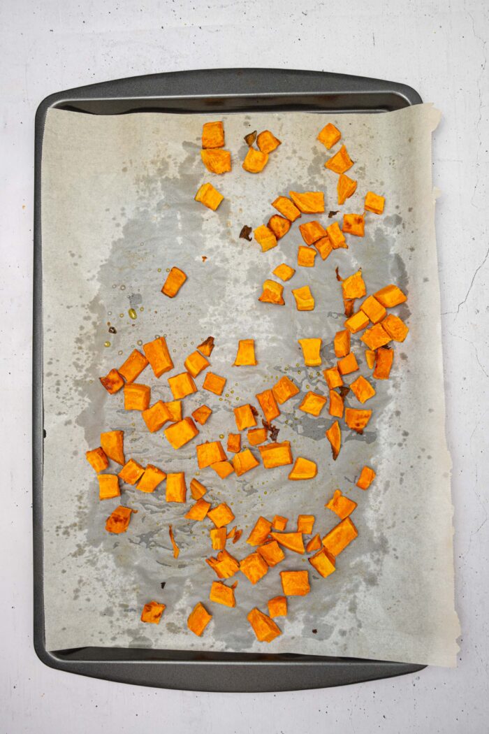 Cooked cubed sweet potatoes, still on the sheet pan tray.