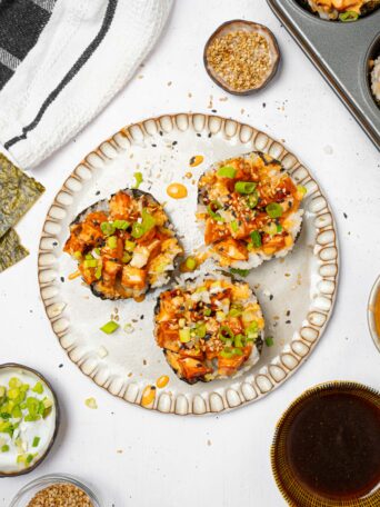 Sushi cups served on a plate with green onions and sesame seeds.
