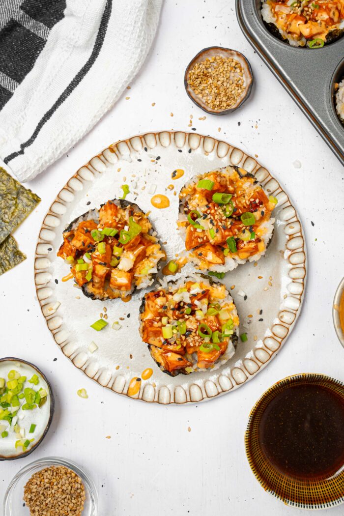 Sushi cups served on a plate with green onions and sesame seeds.
