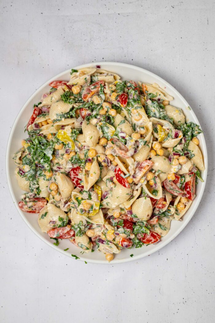A serving of spicy pasta salad in a bowl against a plain background.