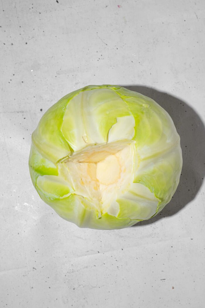 A full head of cabbage, with the thick stem cut out from the bottom.