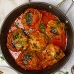 A pan with vegan cabbage rolls served with fresh herbs.