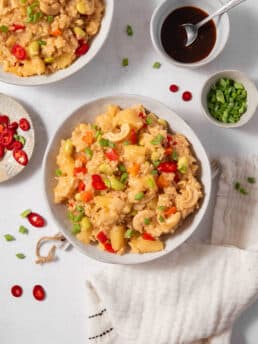 A serving of pineapple rice in a bowl, with garnishes visible in-shot.