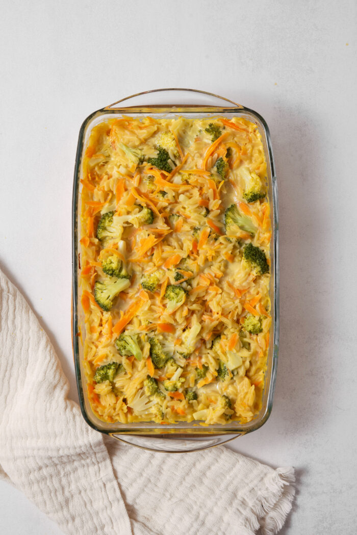 After cooking in the oven, the vegan broccoli cheddar orzo absorbs the liquid and sets into a casserole.