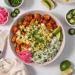 A serving of street corn salad with herb rice and spicy tofu cubes.