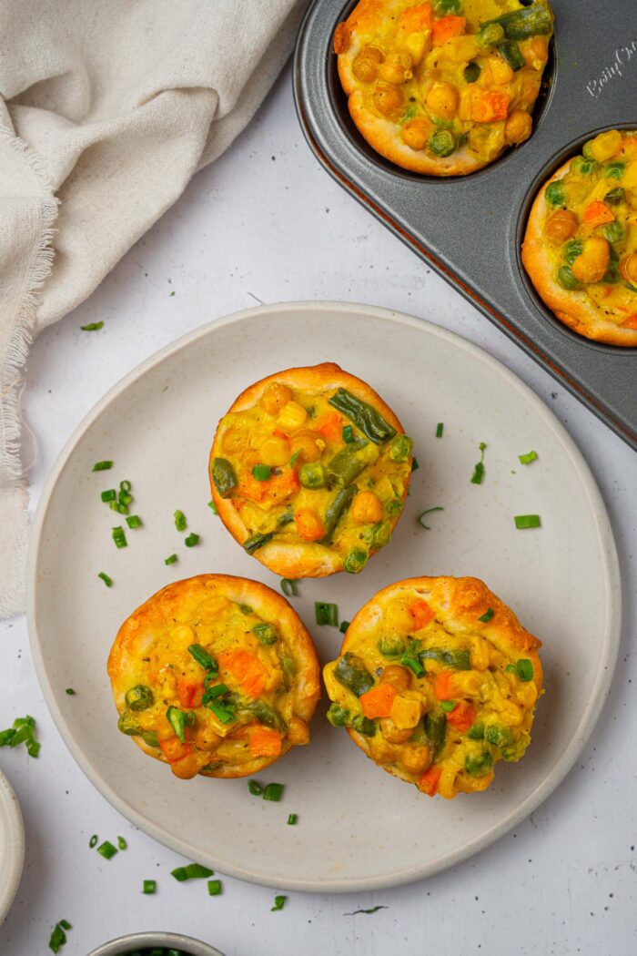 Three mini chickpea pot pies served with fresh chives.