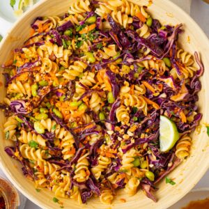 Peanut pasta salad mixed all together in a large wooden salad bowl.