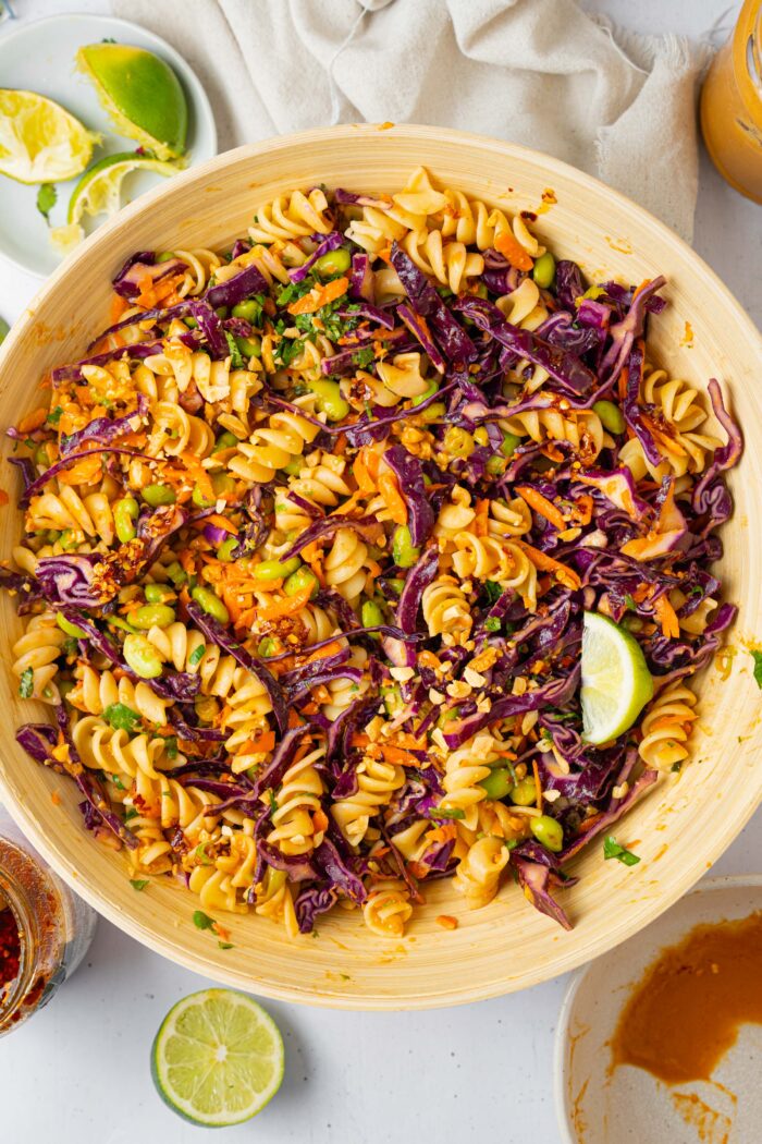 Peanut pasta salad mixed all together in a large wooden salad bowl.