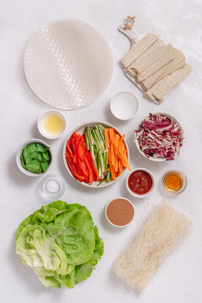 The ingredients for vegan summer rolls laid out on a plain white background.