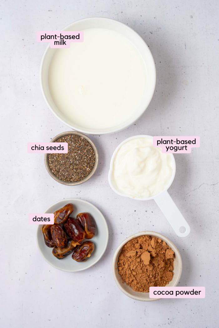 The ingredients for the blended chocolate chia pudding laid out and labeled on a clear white background.