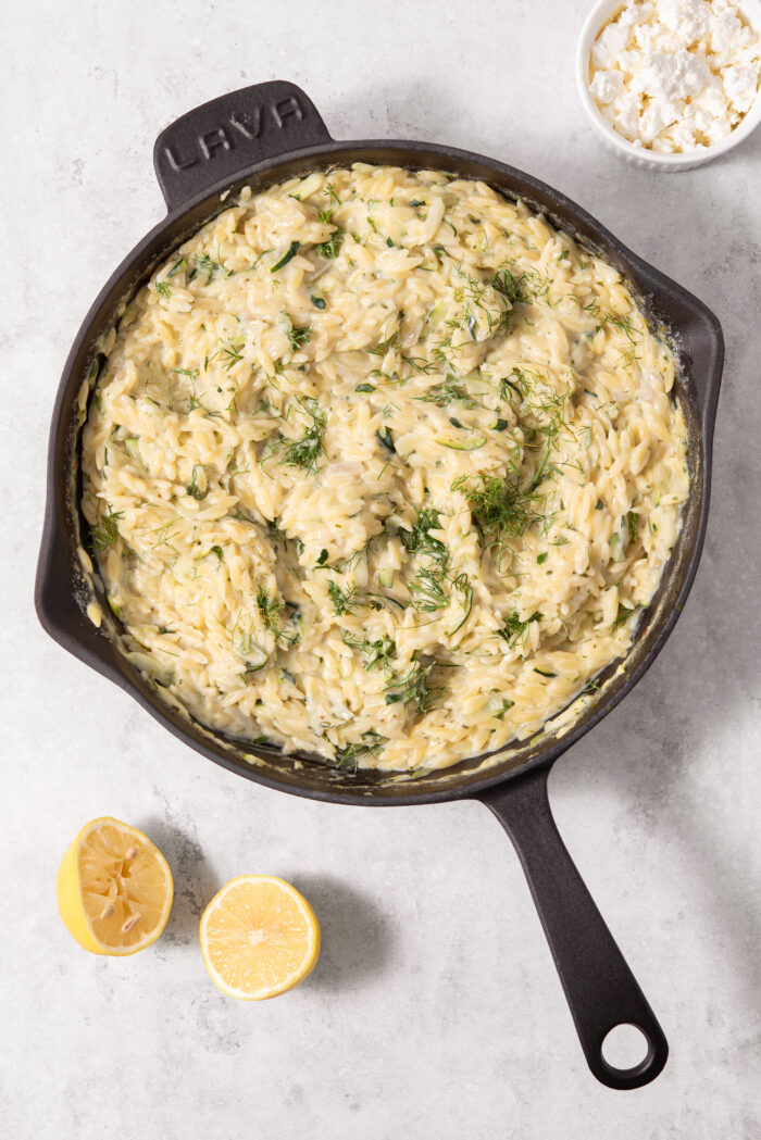 The zucchini orzo cooks all together in a large pan until it is creamy and chewy.
